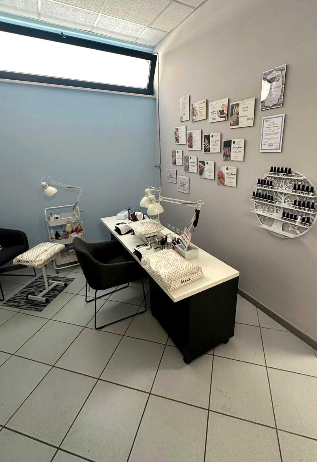 Cabina manicure professionale in centro estetico Postazione manicure con tavoli attrezzati, lampade professionali e smalti in un centro estetico moderno e ordinato.